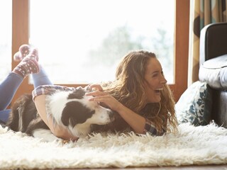 Sıcacık evinde köpeği ile birlikte huzur bulan bir kadın